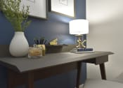 Thumbnail 10 of 27 - a desk with a lamp and a vase on it