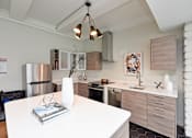 Thumbnail 16 of 51 - A modern kitchen with a white table and a stainless steel refrigerator.