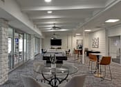 Thumbnail 24 of 51 - A modern dining room with a glass table surrounded by grey chairs.