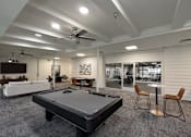Thumbnail 21 of 51 - A room with a pool table and a fan.
