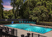 Thumbnail 12 of 16 - Greentree Apartments in Savannah, GA photo of a resort style swimming pool with blue chairs around it