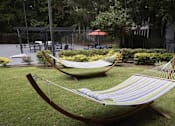 Thumbnail 4 of 16 - Greentree Apartments in Savannah, GA photo of two hammocks on the lawn in a garden