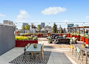 Thumbnail 19 of 20 - A patio with a table and chairs overlooks a city skyline.