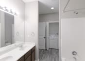 Thumbnail 9 of 21 - a bathroom with two sinks and a mirror and a laundry room