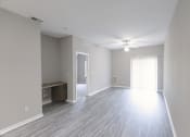 Thumbnail 7 of 21 - an empty living room with wood flooring and a ceiling fan