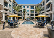 Thumbnail 1 of 21 - A large courtyard with a pool surrounded by apartment buildings.