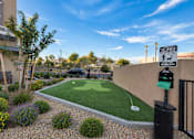 Thumbnail 6 of 21 - A small putting green is surrounded by a low fence and a sign that says "Pet Waste.".
