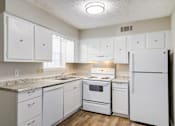 Thumbnail 6 of 12 - Affinitee at Pine Lake Apartments in Pine Lake, GA photo of a white kitchen with white appliances and white cabinets