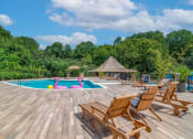 Thumbnail 6 of 16 - Affinitee at Stone Mountain Apartments photo of a swimming pool with deck chairs around it