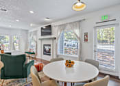 Thumbnail 19 of 34 - A living room with a white table and chairs.