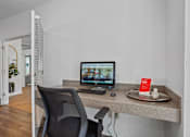 Thumbnail 20 of 34 - A black chair is in front of a desk with a computer and a mouse.