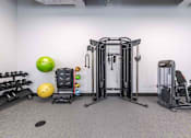 Thumbnail 22 of 37 - A gym with a variety of equipment including a leg press machine, a weight bench, and a dumbbell rack.