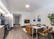 Thumbnail 5 of 37 - Open-concept living room, dining area, and kitchen in a modern, pet-friendly Miami Beach apartment featuring energy-efficient appliances, sleek finishes, and natural lighting.