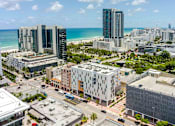 Thumbnail 32 of 37 - High-angle view of a modern, pet-friendly Miami Beach apartment complex surrounded by city infrastructure.