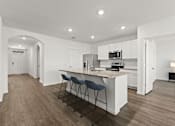 Thumbnail 5 of 35 - A kitchen with white cabinets and a countertop with a bar stool.