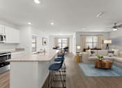 Thumbnail 6 of 35 - A modern kitchen with a bar area and a living room with a couch.