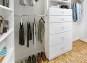 Thumbnail 22 of 66 - A white closet with clothes and shoes.