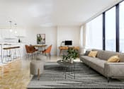Thumbnail 20 of 66 - A modern living room with a grey sofa, wooden floors, and a kitchen area in the background.
