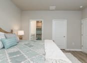 Thumbnail 22 of 62 - a bedroom with a bed and a door to a bathroom