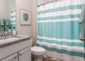 Thumbnail 27 of 62 - a bathroom with a blue and white shower curtain
