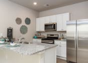 Thumbnail 32 of 62 - a kitchen with a counter top and a refrigerator