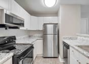 Thumbnail 7 of 23 - Ashford at Spring Lake apartments in Atlanta Georgia photo of kitchen with stainless steel appliances