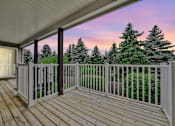 Thumbnail 9 of 15 - Pet-Friendly Apartments in Geneva, IL – Ashford at Geneva –  A wooden deck with a white railing and a view of trees.