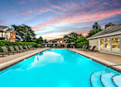 Thumbnail 2 of 15 - Apartments in Geneva, IL for Rent- Ashford at Geneva- A long rectangular swimming pool with a blue tinted water.