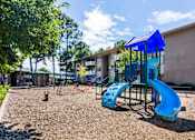 Thumbnail 3 of 24 - On-site playground with slides and mulch ground at this Atlanta apartment community.