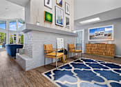 Thumbnail 12 of 29 - A living room with a blue rug and a white fireplace.