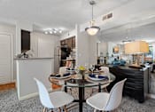 Thumbnail 25 of 29 - A modern dining room with a glass table and white chairs.