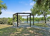 Thumbnail 11 of 29 - A gazebo in a park with a lake in the background.