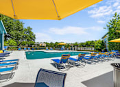 Thumbnail 5 of 29 - A pool area with sun loungers and a yellow canopy.