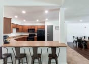 Thumbnail 19 of 21 - a kitchen and dining area with a bar and chairs