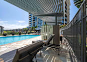 Thumbnail 14 of 29 - Irvine, CA, Apartments for Rent - Astoria at Central Park West - Gated Pool with Lounge Chairs, Umbrellas, and Potted Plants.