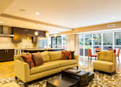 Thumbnail 21 of 29 - A living room with a yellow couch and a coffee table.