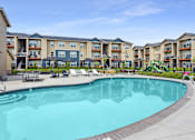 Thumbnail 32 of 47 - a swimming pool with an apartment building in the background
