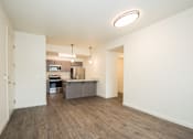 Thumbnail 5 of 47 - an empty living room with a kitchen with a counter top and