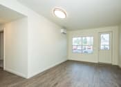 Thumbnail 7 of 47 - an empty living room with white walls and wood flooring