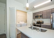 Thumbnail 2 of 47 - a kitchen with white counter tops and a stainless steel sink