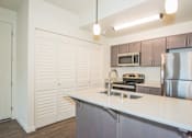 Thumbnail 3 of 47 - a kitchen with an island and a stainless steel refrigerator