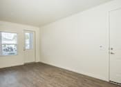 Thumbnail 8 of 47 - Upscale Apartments in Vancouver, WA - Autumn Grove - Living Room with Wood-Style Flooring, White Walls, Large Window, and AC Unit.