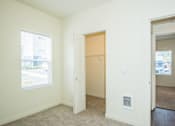 Thumbnail 11 of 47 - Two-Bedroom Luxury Apartments in Vancouver, WA - Autumn Grove - Bedroom with Carpeted Flooring, Large Window, Spacious Closet, and Attached Bathroom.