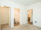 Thumbnail 17 of 47 - a bedroom with two closets and a bathroom with a toilet