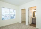 Thumbnail 16 of 47 - Two-Bedroom Luxury Apartments in Vancouver, WA - Autumn Grove - Bedroom with Carpeted Flooring, Large Window, Spacious Closet, and Attached Bathroom.