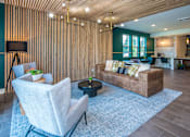 Thumbnail 21 of 47 - Vancouver, WA Luxury Apartments for Rent - Autumn Grove - Clubhouse with Carpeted Flooring, Leather Sofa, Wingback Armchairs, Coffee Table, Wooden Panel Walls, and Floor-to-Ceiling Windows.