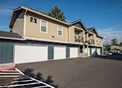 Thumbnail 43 of 47 - a large yellow house with a garage and a driveway