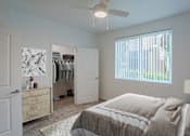 Thumbnail 36 of 38 - A bedroom with a large bed and a closet with clothes hanging.