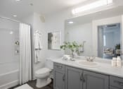 Thumbnail 34 of 38 - A white toilet sits in a bathroom next to a sink.