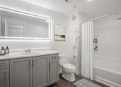 Thumbnail 25 of 38 - A white bathroom with a sink, toilet, and bathtub.